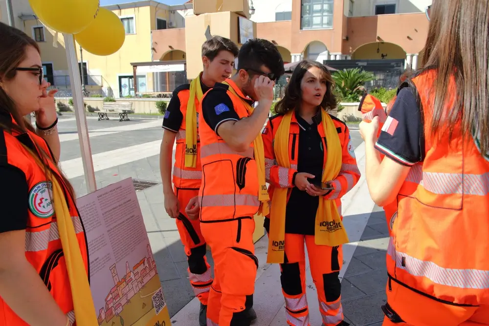 Recrues de la protection civile en tenue d'urgence orange lors d'une formation de terrain pour le recrutement.