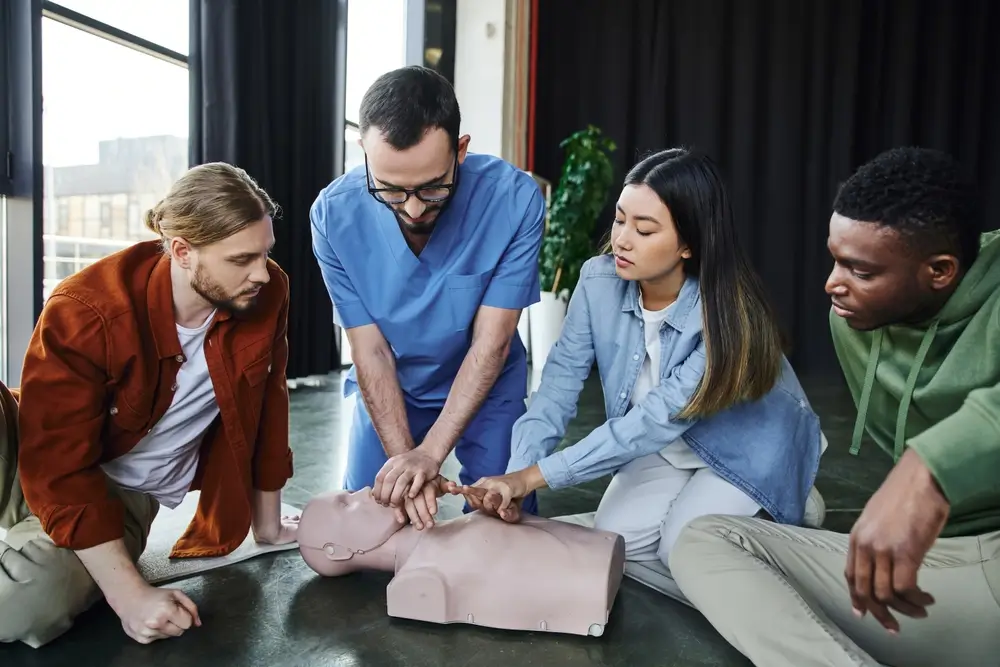 Candidats en formation de secours pratiquant un massage cardiaque sur un mannequin d'entraînement.