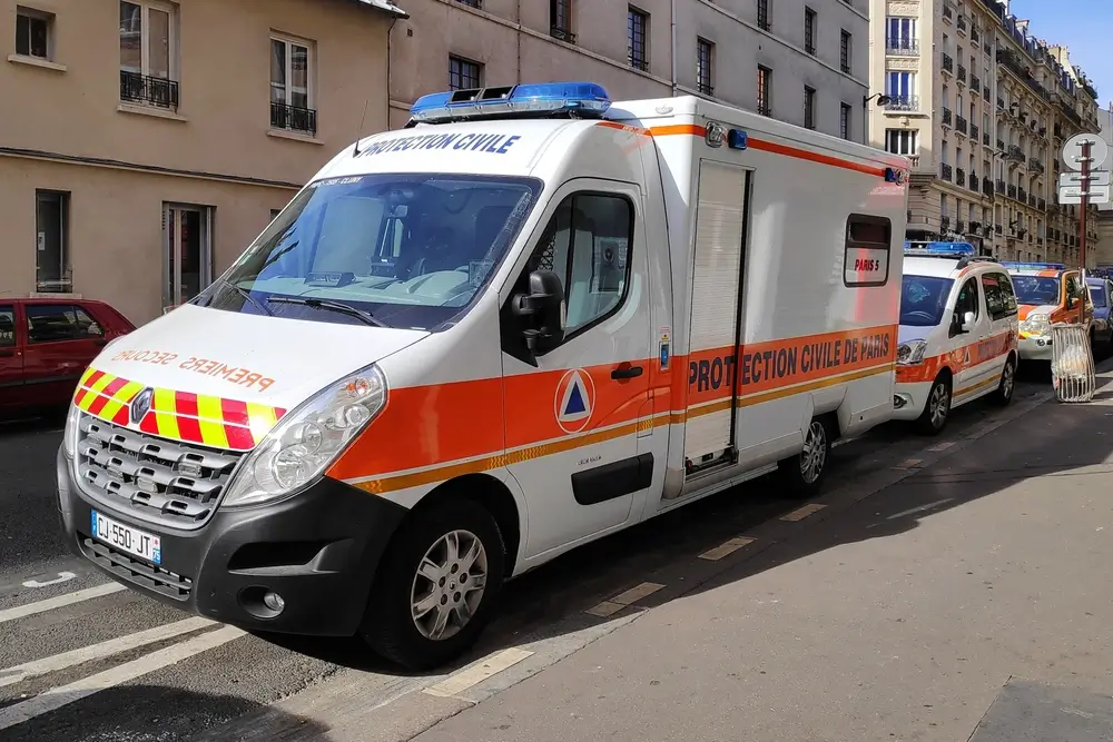 Véhicule de premiers secours de la Protection civile stationné près d'une caserne ou d'un centre d'intervention.