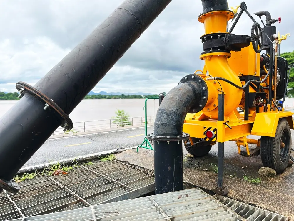 Pompe inondation haute capacité jaune déployée sur une route lors d'une intervention technique de pompage lourd.