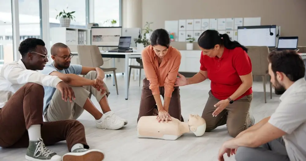 Agents de secours en formation pratiquant un massage cardiaque sur un mannequin lors d'un entraînement collectif.