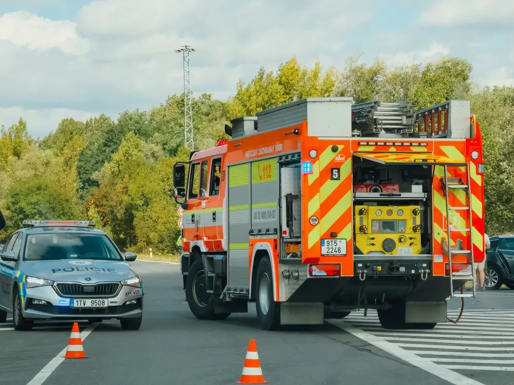 Coordination d'équipes de secours lors d'une intervention avec un camion de pompiers et un véhicule de police.
