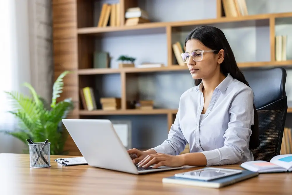 Candidate concentrée passant un examen de recrutement en ligne sur ordinateur pour un test de sélection Selor.