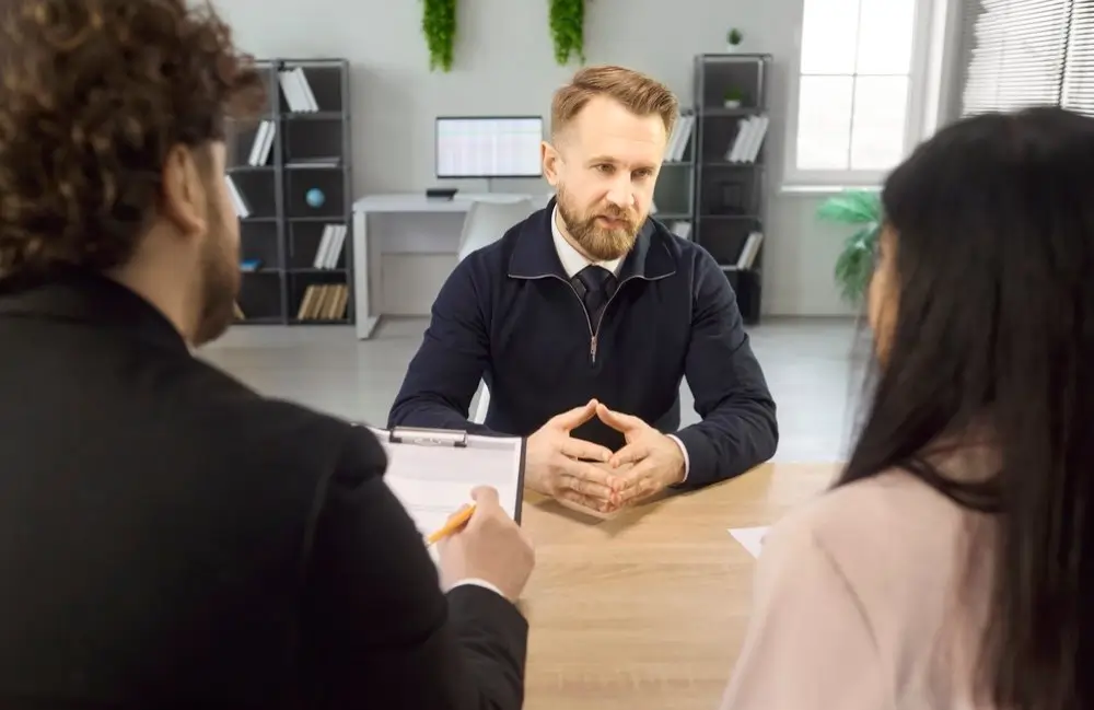 Candidat attentif répondant aux questions d'un jury de recrutement lors d'un entretien d'embauche professionnel.