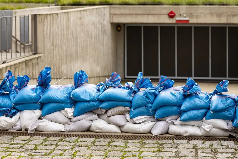 Rue inondée avec sacs de sable empilés pour contenir la montée des eaux