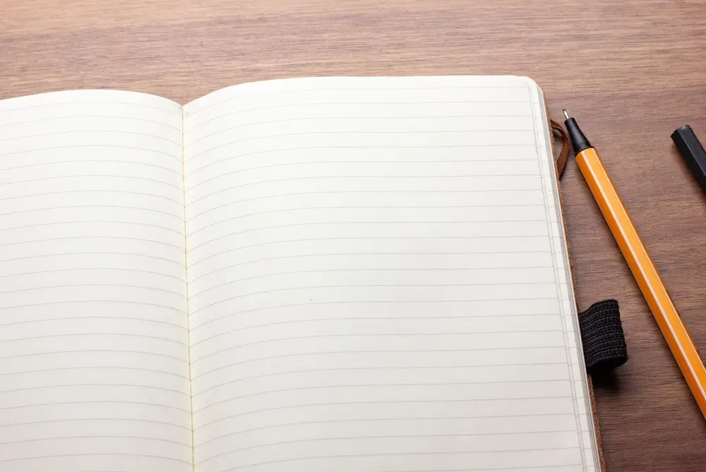 Carnet de notes ouvert et stylo sur un bureau pour la préparation et la coordination de gestion de crise.