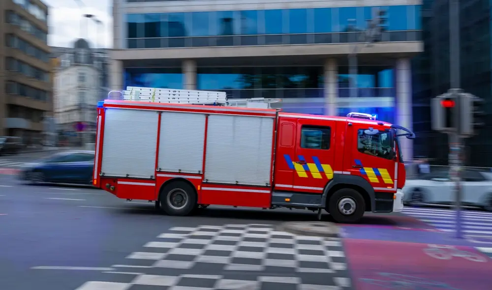 Camion de la protection civile belge circulant rapidement en ville pour une mission d'intervention d'urgence.