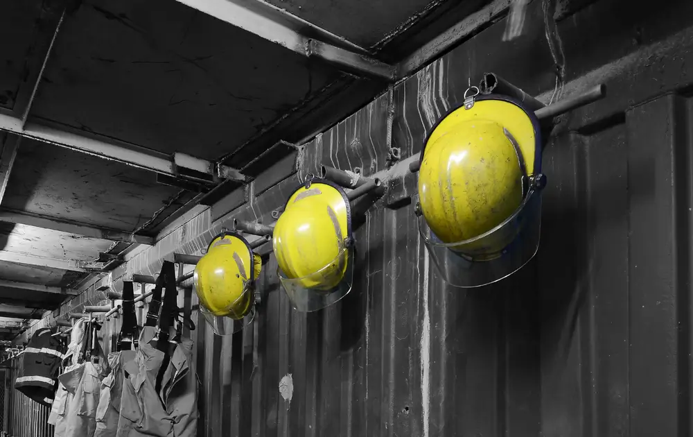 Trois casques de pompier jaunes en gros plan, matériel d'intervention prêt pour les missions de secours.