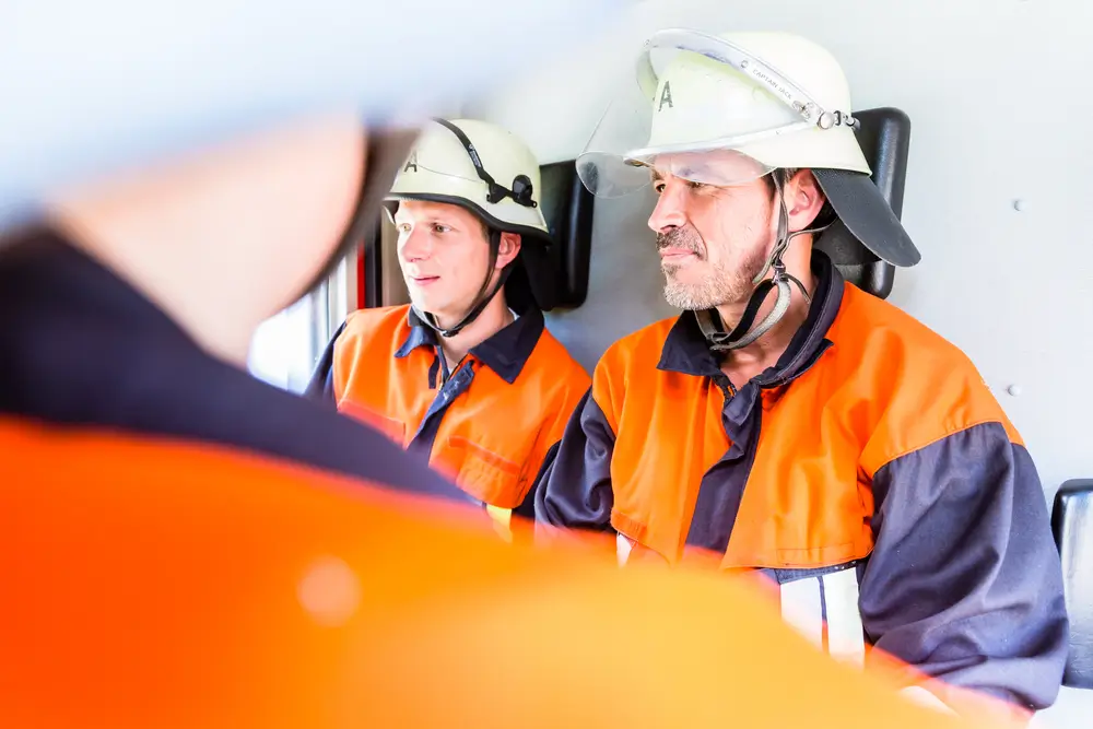 Équipe de secours de la Protection civile en réunion de briefing à bord d'un véhicule avant une intervention.